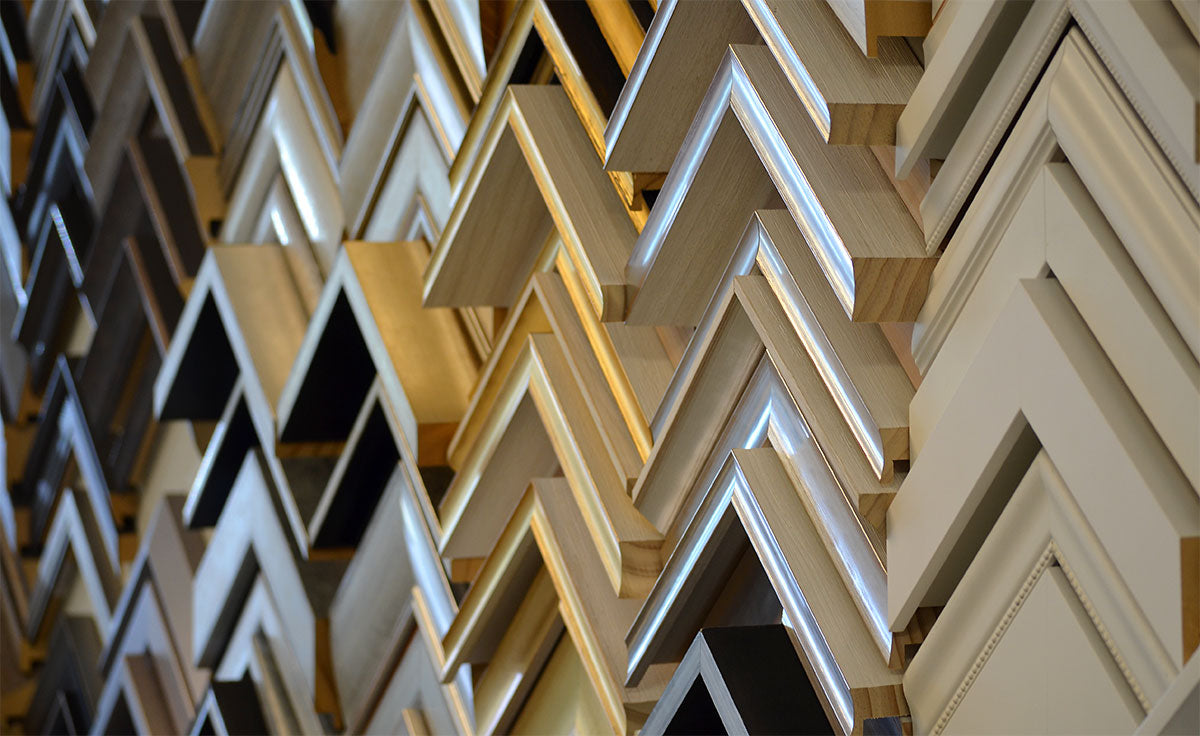 Display of picture frame corner samples showing a variety of frame styles and finishes.