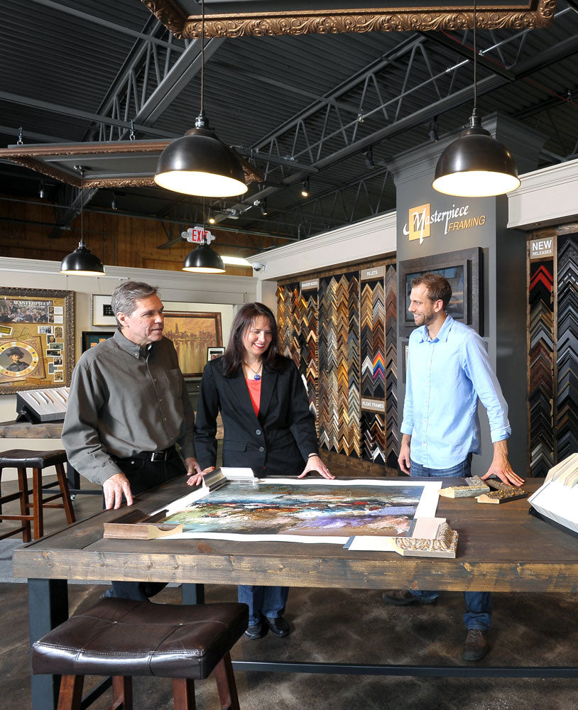 Interior of Masterpiece Framing Bloomingdale showroom with team consulting on custom framing project.