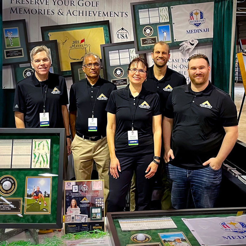 Masterpiece Framing team at corporate event showcasing custom framed memorabilia and commercial framing projects.