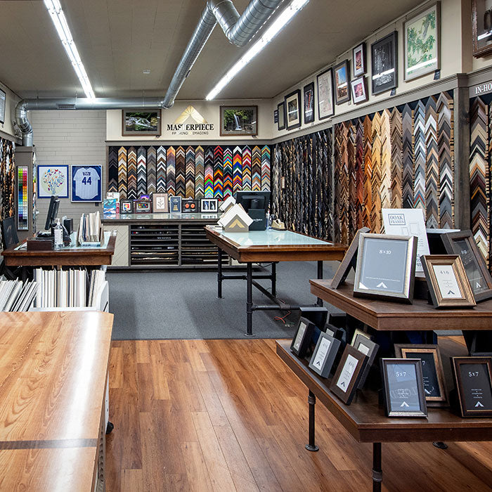 Interior of Masterpiece Framing & Imaging in Evanston, Illinois, featuring walls of custom picture frame moulding samples, framed artwork and design consultation tables.